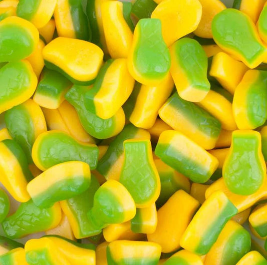 Close-up of yellow and green gummy candy shaped like pineapples.