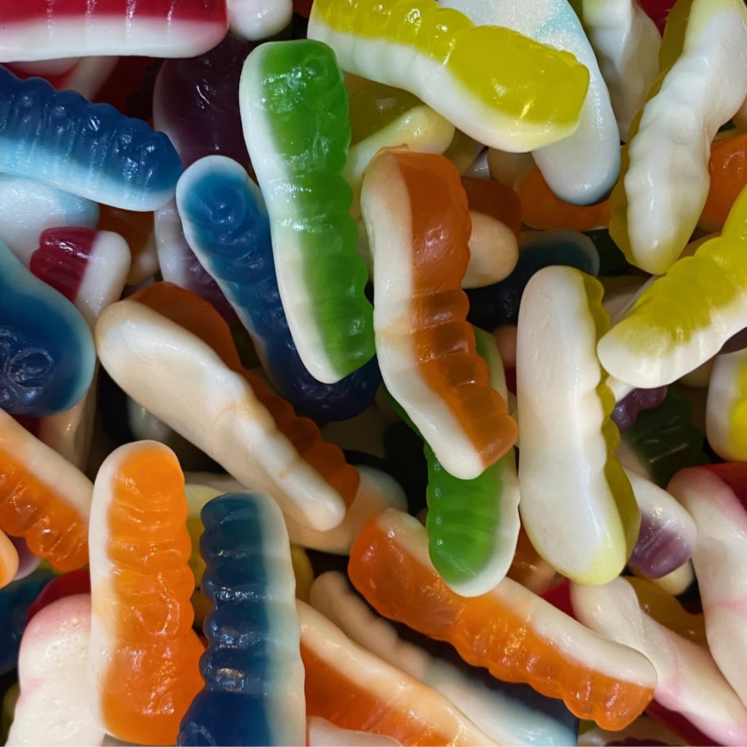 Colorful gummy witchity grub candies in white, orange, blue, green, yellow, and purple with segmented grub-like textures and realistic larva shapes